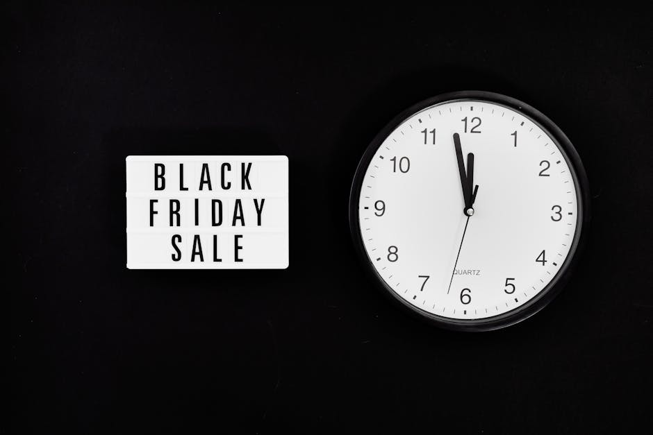 A black background with a small rectangular lightbox displaying the text 'BLACK FRIDAY SALE' in black capital letters on a white background, positioned to the left. To the right, there is a white roun